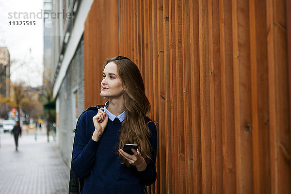 Entspannte junge Frau mit Smartphone