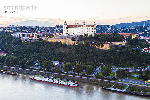 Slowakei  Bratislava  Blick zur Burg mit Flusskreuzfahrtschiff auf der Donau im Vordergrund bei Dämmerung