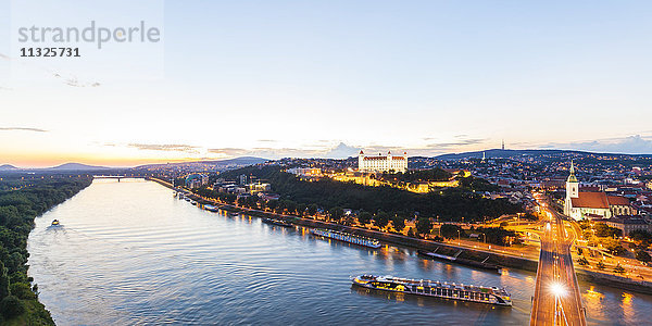 Slowakei  Bratislava  Stadtlandschaft mit Flusskreuzfahrtschiffen auf der Donau in der Abenddämmerung