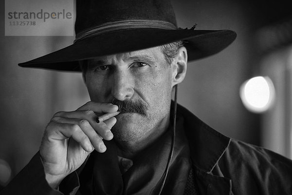 Porträt eines rauchenden Outlaws im Wilden Westen