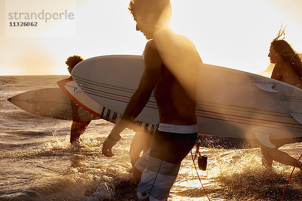Surfer im Meer bei Sonnenuntergang