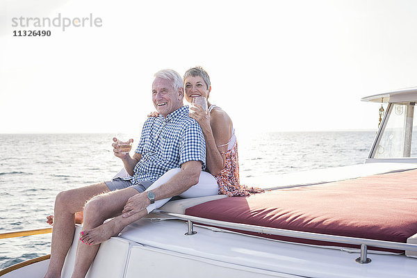 Glückliches Paar bei einem Drink auf einer Bootsfahrt