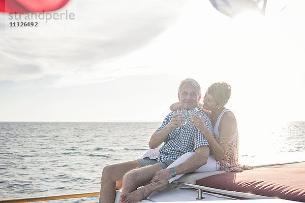 Glückliches Paar bei einem Drink auf einer Bootsfahrt
