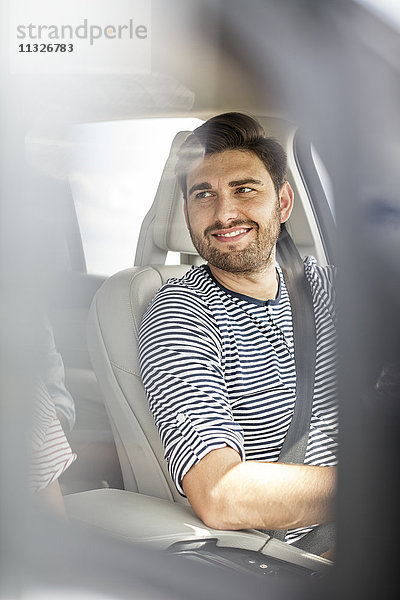 Mittlerer erwachsener Mann beim Autofahren