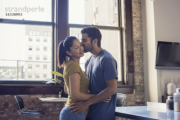 Junges Paar beim Küssen in der Küche