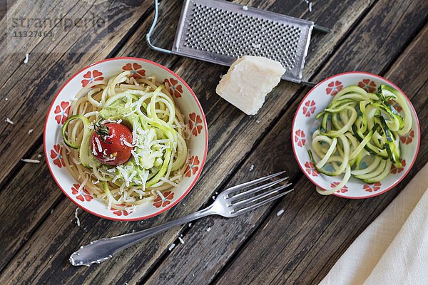 Schale mit Spaghetti  Zucchini-Spaghetti  Guacamole  Kirschtomaten und geriebenem Parmesan
