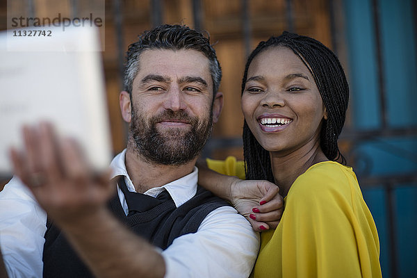 Mann und lächelnde Frau nehmen einen Selfie mit Tablette