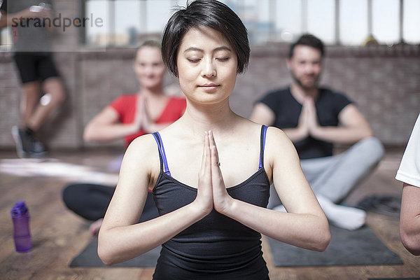 Junge Frau beim Yoga-Meditationstraining im Studio