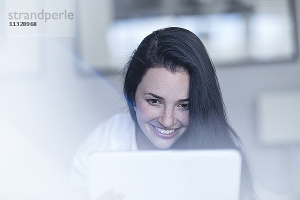 Porträt einer lächelnden jungen Frau mit Tablette