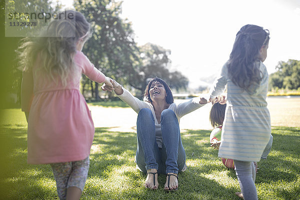 Zwei Mädchen  die mit ihrer Mutter im Park spielen.