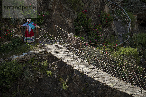 Frau auf Drehbrücke im Colca Canyon in Peru