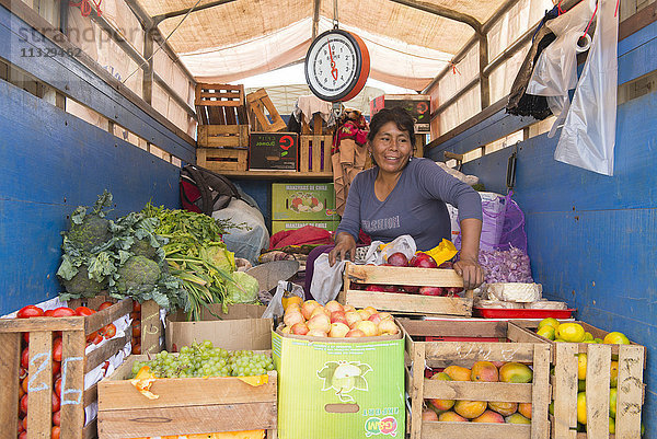 Frau verkauft Gemüse aus einem Lastwagen in Peru
