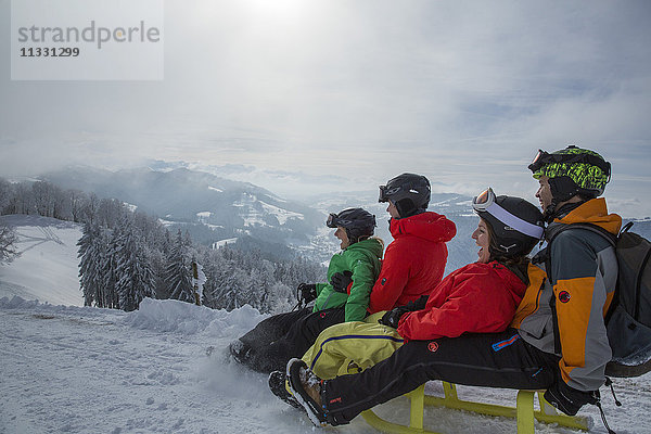Gruppe beim Schlittenfahren im Winter in der Schweiz
