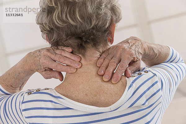 Ältere Frau mit Schmerzen in der Halswirbelsäule.