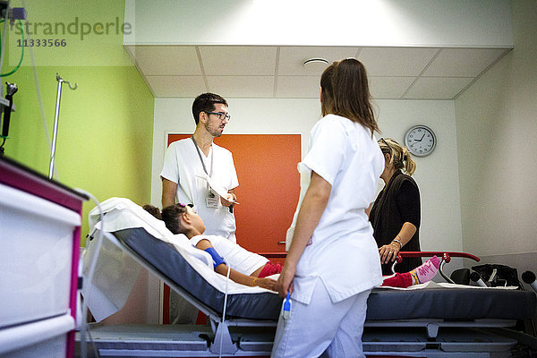 Reportage aus der pädiatrischen Notaufnahme eines Krankenhauses in Haute-Savoie  Frankreich. Eine Krankenschwester und eine Hilfskrankenschwester sprechen mit einer jungen Patientin und ihrer Mutter.