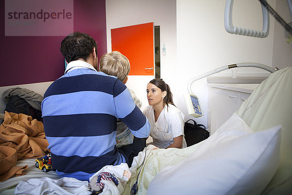 Reportage aus der pädiatrischen Notaufnahme eines Krankenhauses in Haute-Savoie  Frankreich. Eine Krankenschwester spricht mit dem Vater eines jungen Patienten in der Kurzzeit-Notfallstation.