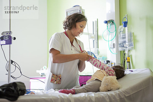 Reportage aus der pädiatrischen Notaufnahme eines Krankenhauses in Haute-Savoie  Frankreich. Eine Hilfskrankenschwester zieht ein Baby aus.