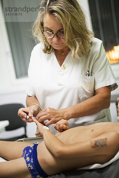 Reportage aus der pädiatrischen Notaufnahme eines Krankenhauses in Haute-Savoie  Frankreich. Eine Krankenschwester führt eine Blutzuckermessung durch.