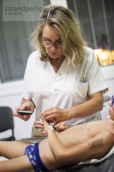 Reportage aus der pädiatrischen Notaufnahme eines Krankenhauses in Haute-Savoie  Frankreich. Eine Krankenschwester führt eine Blutzuckermessung durch.