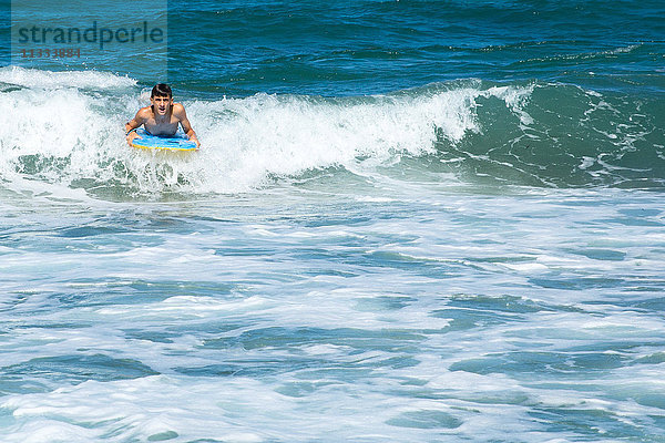 Ein Junge surft auf den Wellen
