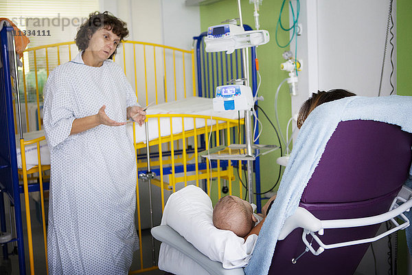 Reportage aus der Kinderabteilung eines Krankenhauses in Haute-Savoie  Frankreich. Ein Arzt spricht mit der Mutter eines Babys im Krankenhaus.