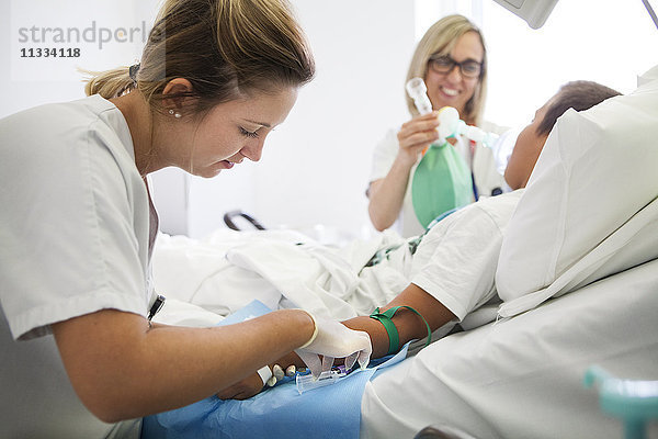 Reportage aus der pädiatrischen Abteilung eines Krankenhauses in Haute-Savoie  Frankreich. Eine Krankenschwester legt einen Katheter  während eine andere eine Maske hält  die Nitronox (eine Mischung aus Gas und Luft) freisetzt.