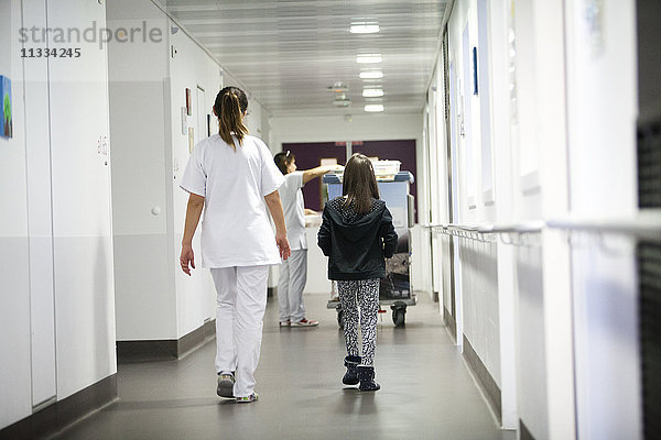 Reportage über die pädiatrische Abteilung eines Krankenhauses in Haute-Savoie  Frankreich. Eine Hilfskrankenschwester bringt einen jungen Patienten in die Kantine.