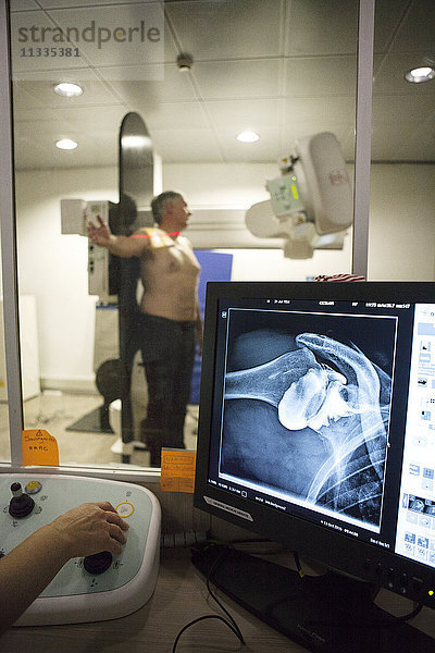 Reportage in einem radiologischen Zentrum in Haute-Savoie  Frankreich. Ein Techniker führt eine Arthographie der Schulter mit Arthrose durch.