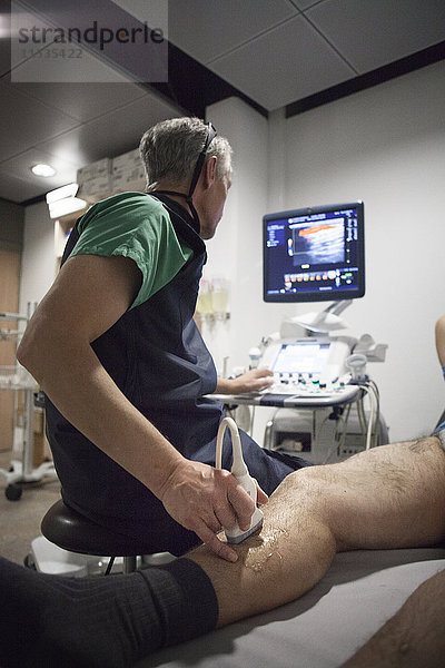 Reportage in einem radiologischen Zentrum in Haute-Savoie  Frankreich. Ein Radiologe führt einen Doppler-Ultraschall bei einem Patienten mit Krampfadern durch.