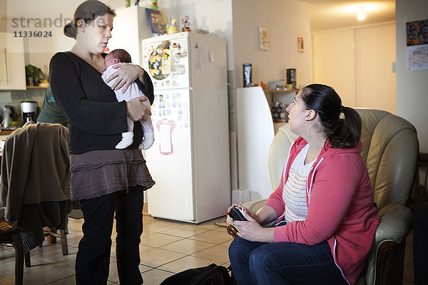 Reportage über eine unabhängige Hebamme bei Hausbesuchen nach der Geburt. Die Hebamme berät die frischgebackenen Eltern.
