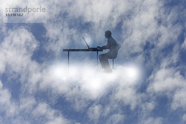 Mann benutzt einen Laptop am Schreibtisch in den Wolken