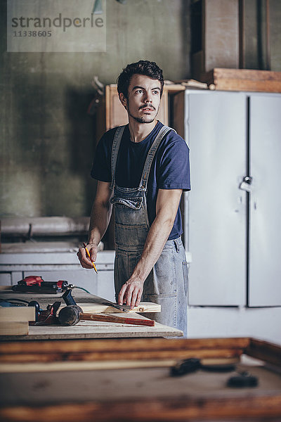 Zimmermann mit Bleistift beim Blick in die Werkstatt