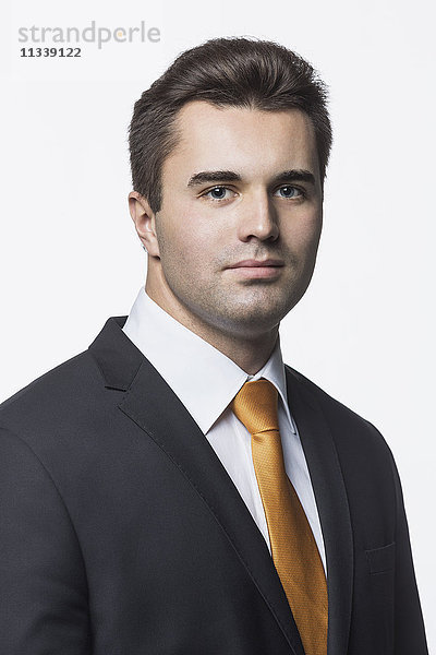 Porträt eines selbstbewussten  gut gekleideten Geschäftsmannes vor weißem Hintergrund