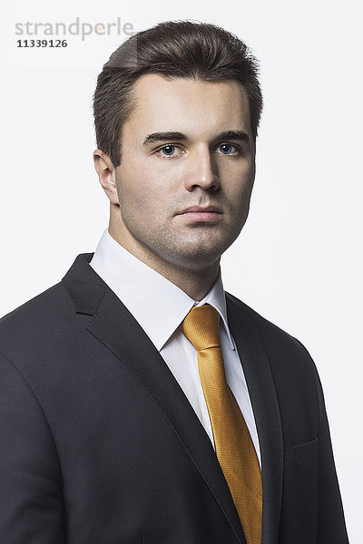 Porträt eines selbstbewussten Geschäftsmannes vor weißem Hintergrund