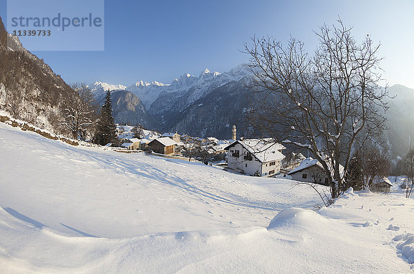 Sonnenuntergang über dem verschneiten Dorf Soglio  Bezirk Maloja  Bergell  Engadin  Kanton Graubünden  Schweiz  Europa