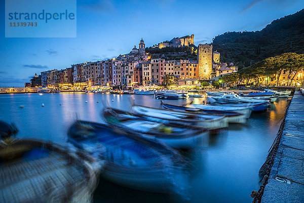 Blick auf das blaue Meer und die Boote  die das bunte Dorf in der Abenddämmerung umgeben  Portovenere  UNESCO-Weltkulturerbe  Provinz La Spezia  Ligurien  Italien  Europa