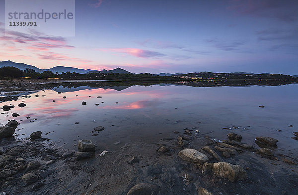 Rosa Wolken bei Sonnenuntergang spiegeln sich im blauen Meer  Villasimius  Provinz Cagliari  Sardinien  Italien  Mittelmeer  Europa