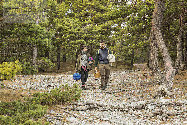 Paar mit Schlafsäcken und Korb im Wald