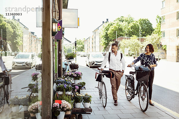 Geschäftsleute mit Fahrrädern auf dem Bürgersteig in der Stadt