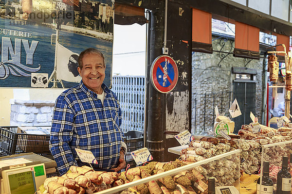 Lächelnder Wurstwarenhändler  Marche Provencal  Morgenmarkt  Vieil Antibes  Französische Riviera  Côte d'Azur  Provence  Frankreich  Europa