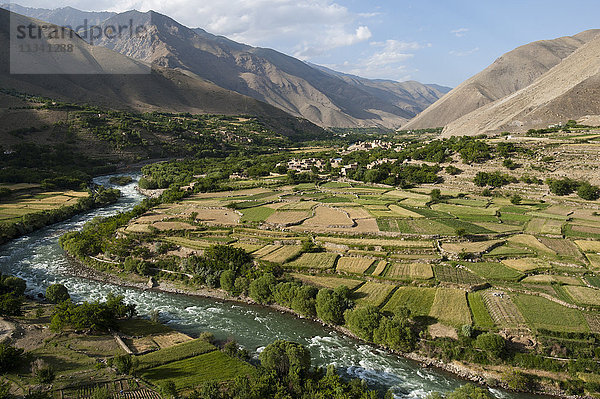 Das Grün der bewässerten Felder kontrastiert mit den trockenen Hügeln darüber  ein Zeugnis für den Einfallsreichtum der Bauern in dieser trockenen Landschaft  Afghanistan  Asien