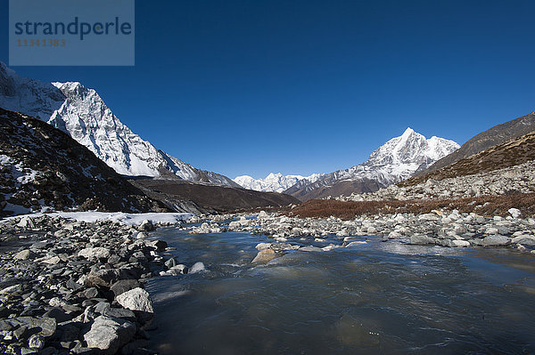 Eisiges Schmelzwasser fließt das Chekhung-Tal hinunter  mit Blick auf die Ama Dablam zur Linken und Taboche zur Rechten  Khumbu-Region  Nepal  Himalaya  Asien