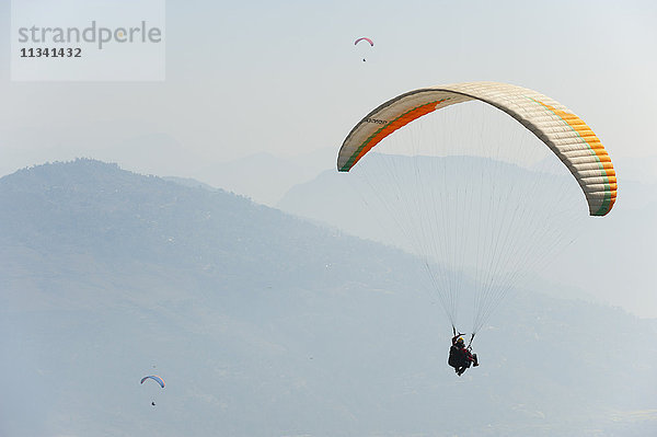 Gleitschirmflieger fliegen über Pokhara  Nepal  Himalaya  Asien