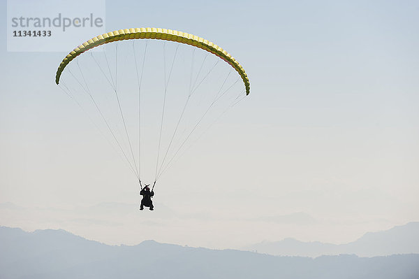 Gleitschirmflieger fliegt über Pokhara  Nepal  Himalaya  Asien