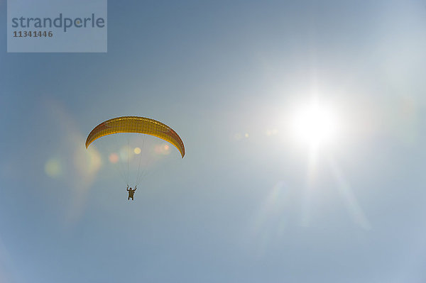 Ein Gleitschirmflieger nähert sich der Landezone über dem Phewa-See in Nepal  Asien