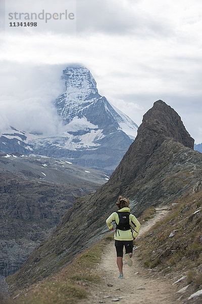 Laufen in den Schweizer Alpen bei Zermatt mit Blick auf das Matterhorn in der Ferne  Zermatt  Wallis  Schweiz  Europa