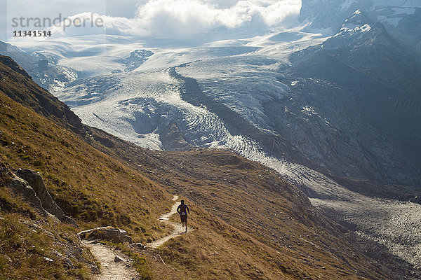 Laufen in den Schweizer Alpen bei Zermatt mit Blick auf den Monte Rosa in der Ferne  Zermatt  Wallis  Schweiz  Europa