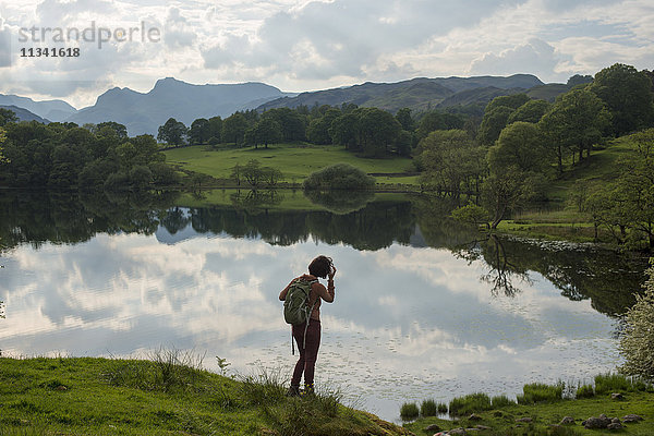 Eine Frau blickt auf den Tarn Foot  Lake District National Park  Cumbria  England  Vereinigtes Königreich  Europa