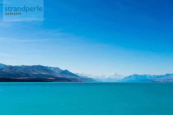 Ein türkisblauer See mit schneebedeckten Bergen in der Ferne  Südinsel  Neuseeland  Pazifik