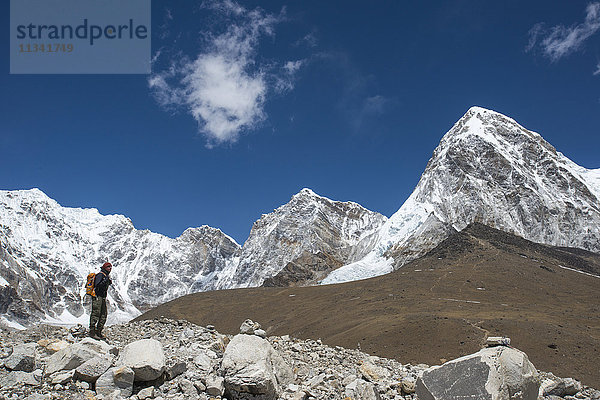 Ein Trekker in der Everest-Region auf dem Weg zum Everest-Basislager  mit Blick auf den Pumori in der Ferne  Khumbu-Region  Himalaya  Nepal  Asien